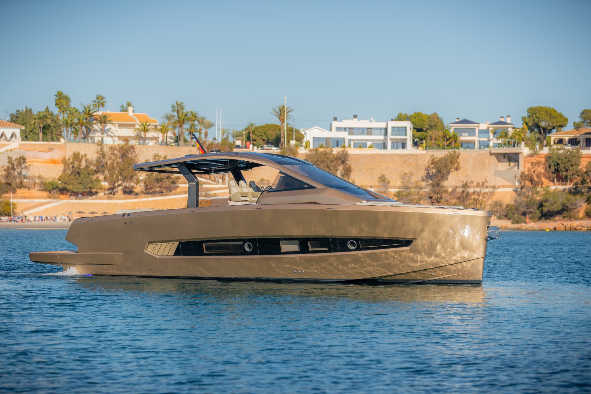 Tesoro T50 Speciale Goldfinger · Armani/Casa yacht charter in Mallorca — cockpit lounge shaded for long Mediterranean lunches, from Club de Mar, Palma.